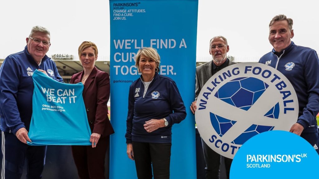 Parkinson’s UK signs deal with Walking Football Scotland teaming up to grow the offer of Parkinson's walking football sessions in Scotland.
Last week, with all the trappings of a club securing a new superstar, the partners signed an agreement at the national stadium, Hampden Park.
Women’s football legend Rose Reilly MBE was on hand to celebrate the deal along with representatives of Parkinson’s UK and Walking Football Scotland.
The agreement sets out how the two organisations will collaborate and share resources with a view to increasing access to walking football opportunities for people with Parkinson’s.