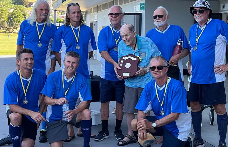 IN A testament to community spirit and sporting camaraderie, the Woopi Old Boys triumphed in a thrilling finale at the inaugural Rotary Daybreak Coffs Harbour Walking Football Charity Shield.
Battling under a scorching sun at Coffs Synthetics, they secured a 2-0 victory over the resilient Coffs City Strollers Red.